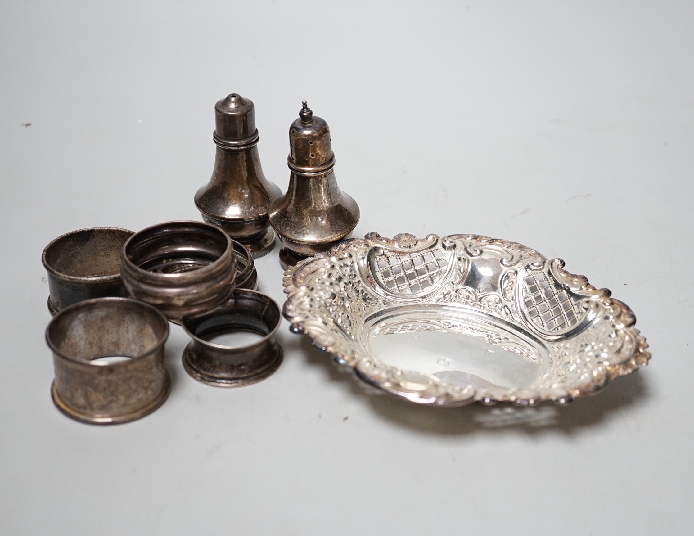 A modern silver bon bon dish, 15.4cm, five silver napkin rings and a pair of silver pepperettes.